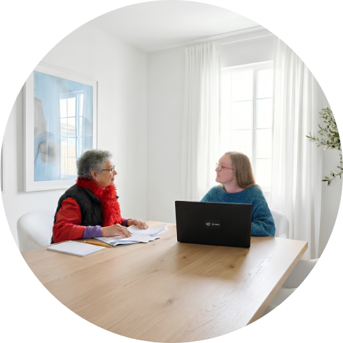 Brenda Sifodaskalakis is speaking with a woman on a bright lit room.