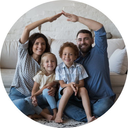 A family of four forms a house shape with their bodies, with the children inside.