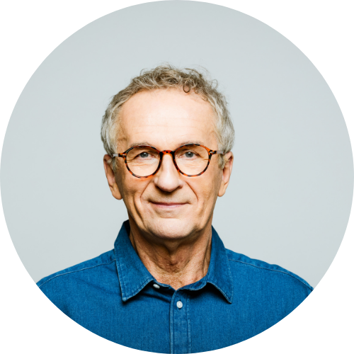 head shot of a man with eyeglasses wearing a denim shirt